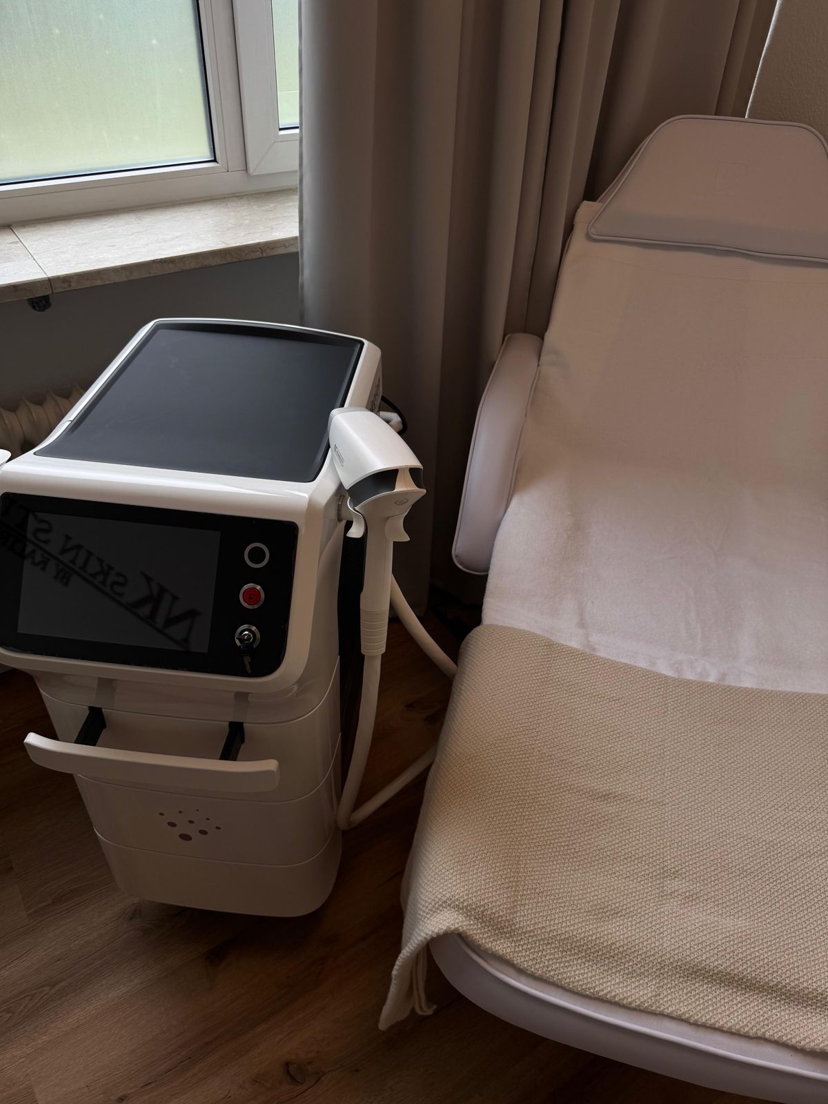 Behandlungsliege mit Decke neben dem Diodenlaser